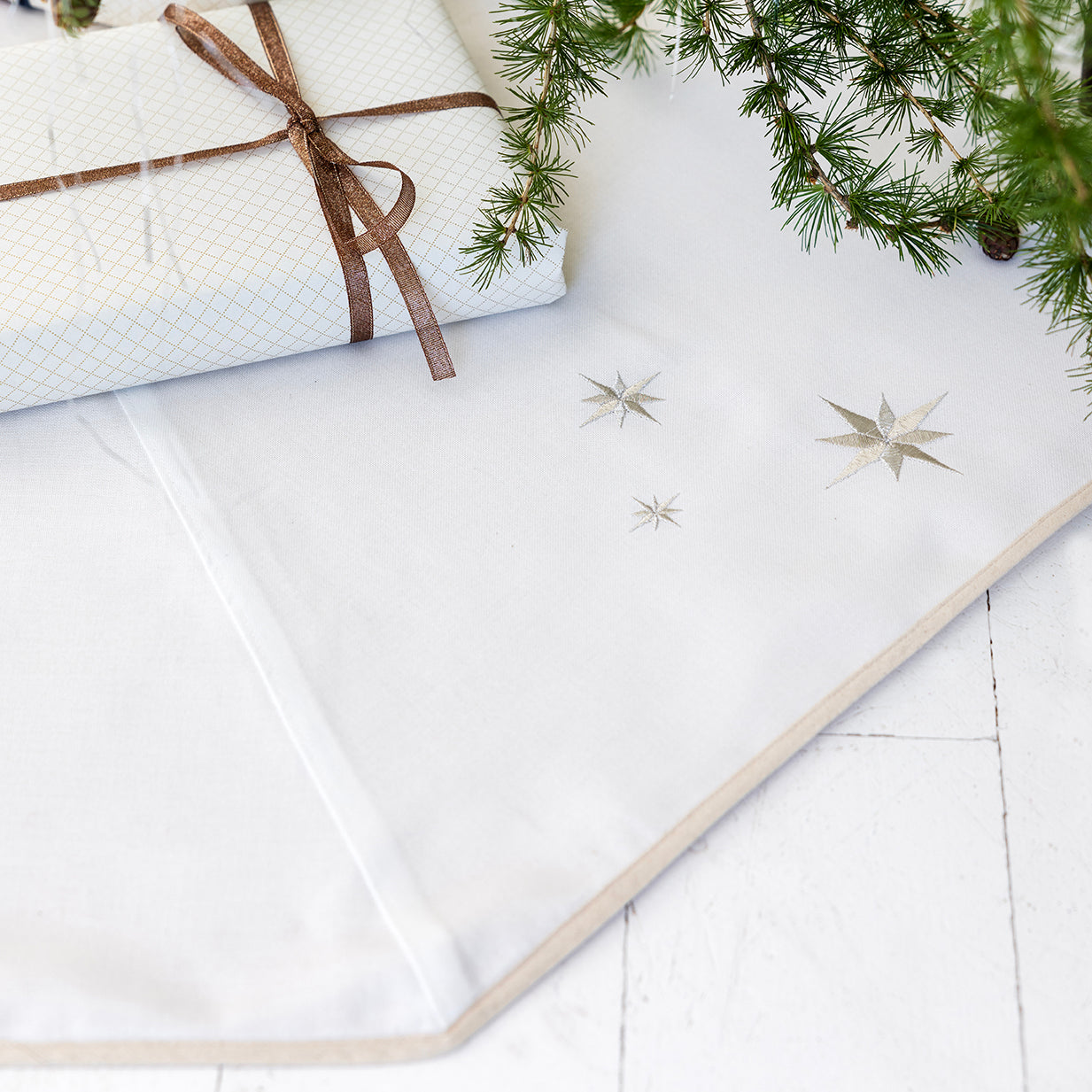 Hvitt juletreteppe med broderte sølvstjerner