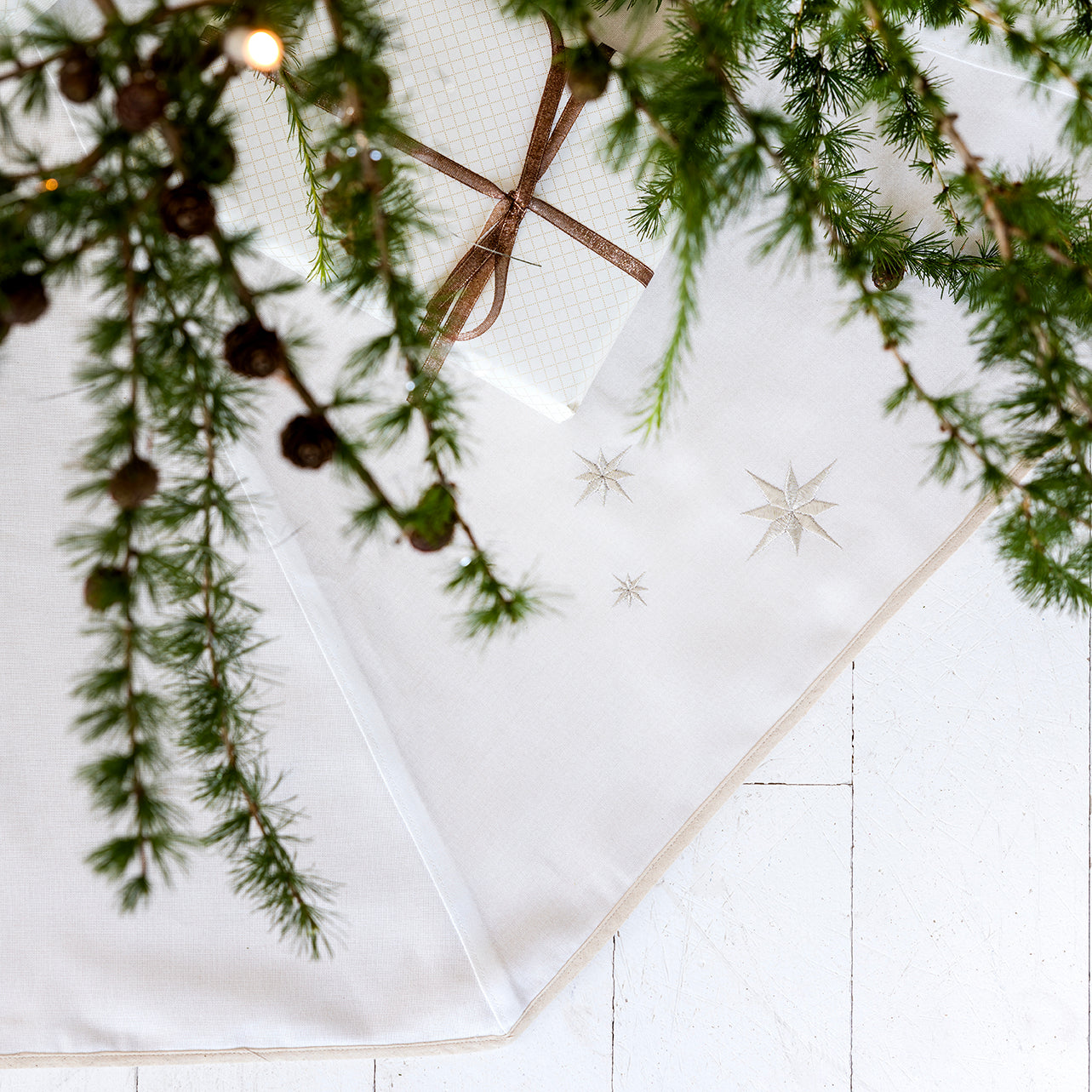 Hvitt juletreteppe med broderte sølvstjerner