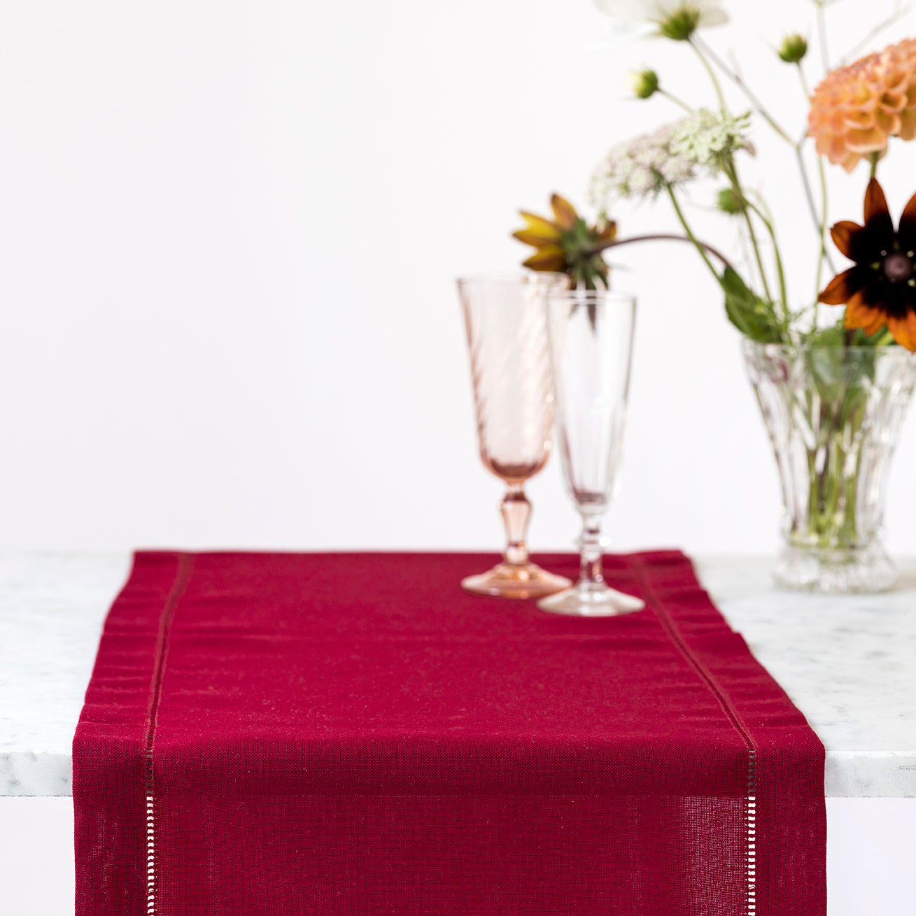 Mørkerød bordløper med brodert hullsøm